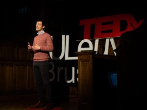 Co-founder of Carbon+Alt+Delete, Kenneth Van den Bergh standing on stage and giving a Tedx Talk at the KULeuven.